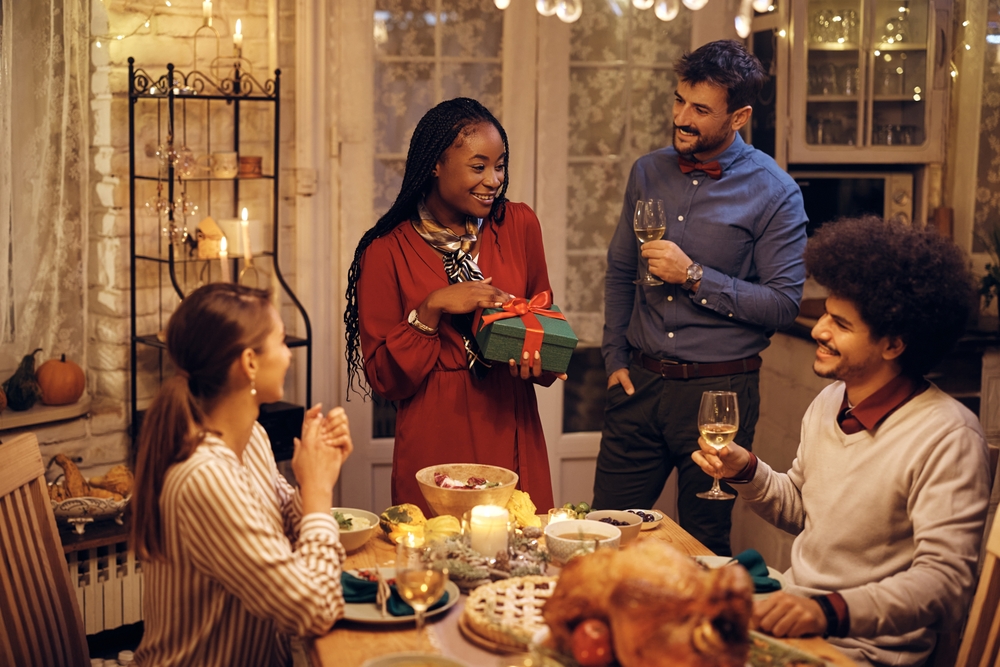 A group of happy friends having dinner together on one of the friend's birthday