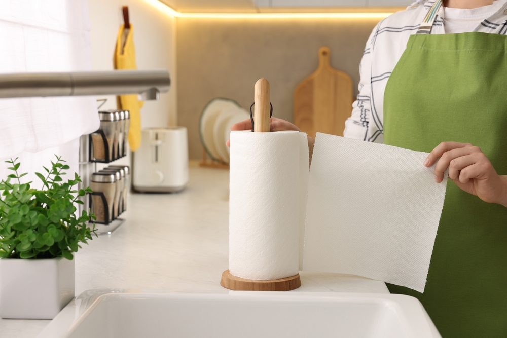 A woman using a paper kitchen towel and napkin