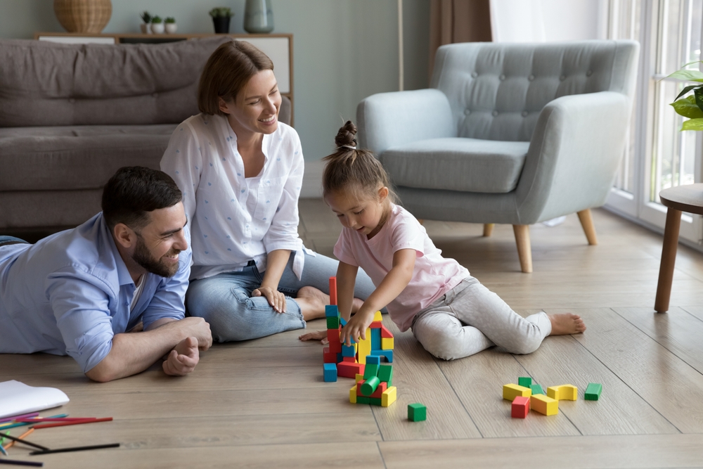 Happy attractive parent playing with their toddler child 