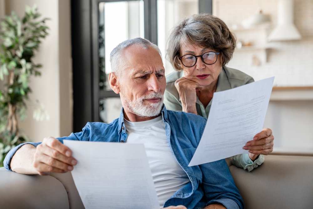 A senior couple reading documents while trying to solve a problem