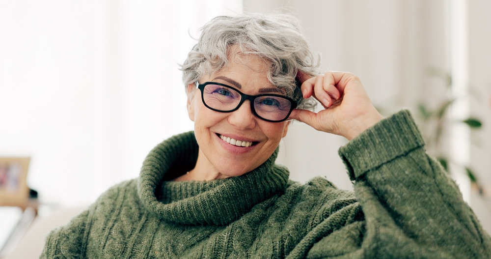 A happy mature senior woman with short gray hair and wearing glasses