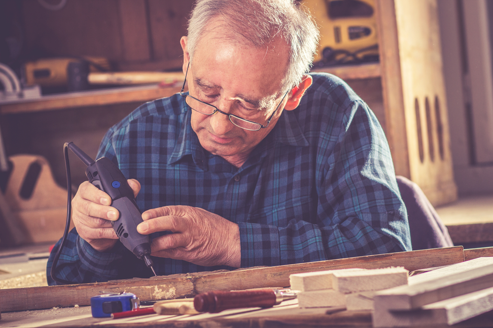 A mature man woodworking as a hobby.