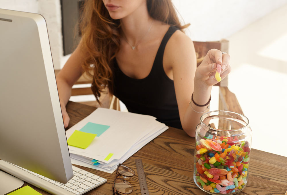 Girl at her computer working or studying eating candy