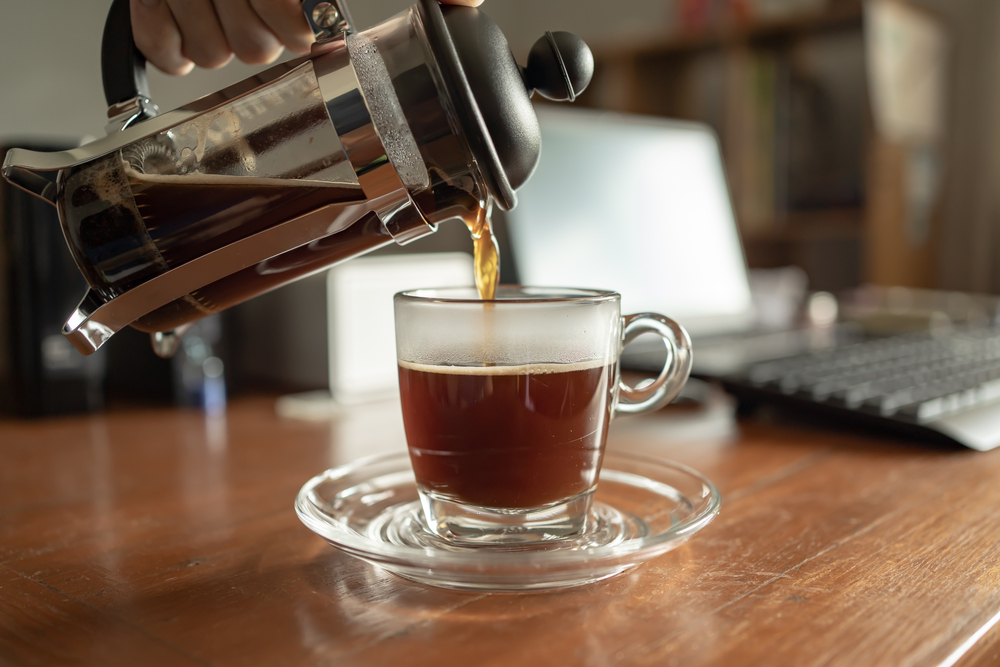 Pouring French press coffee into a cup.