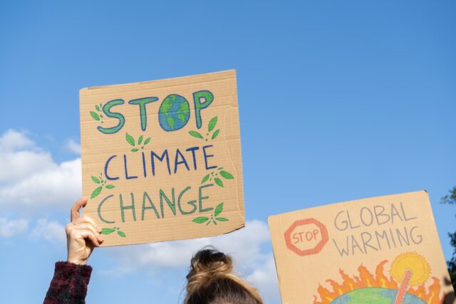 Hands of protesters holding climate change posters.
