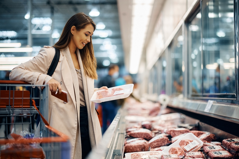 A happy woman going shopping in a grocery store