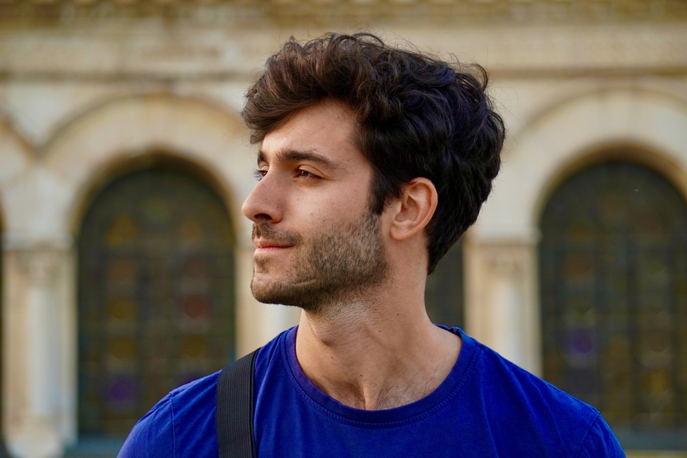 A young man with his face turned sideways, looking sideways