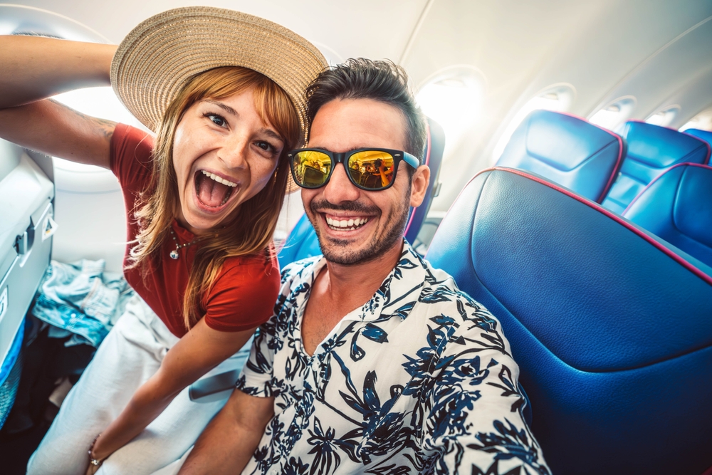 Happy couple on a plan going on vacation.
