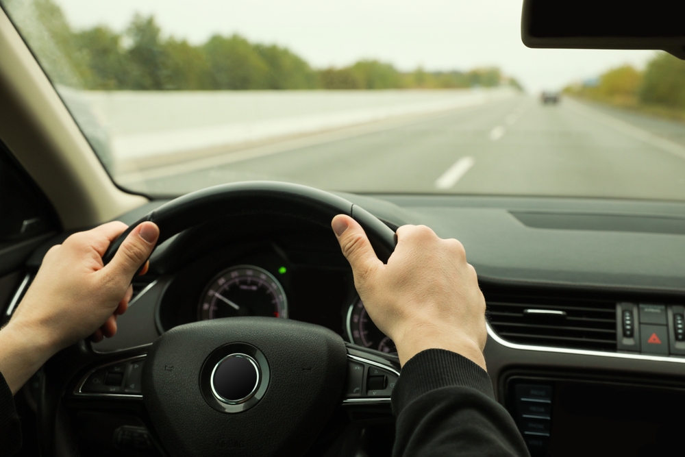 A man at the wheel of his car.