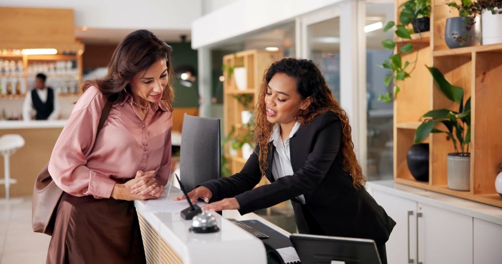Hotel receptionist helping a guest.