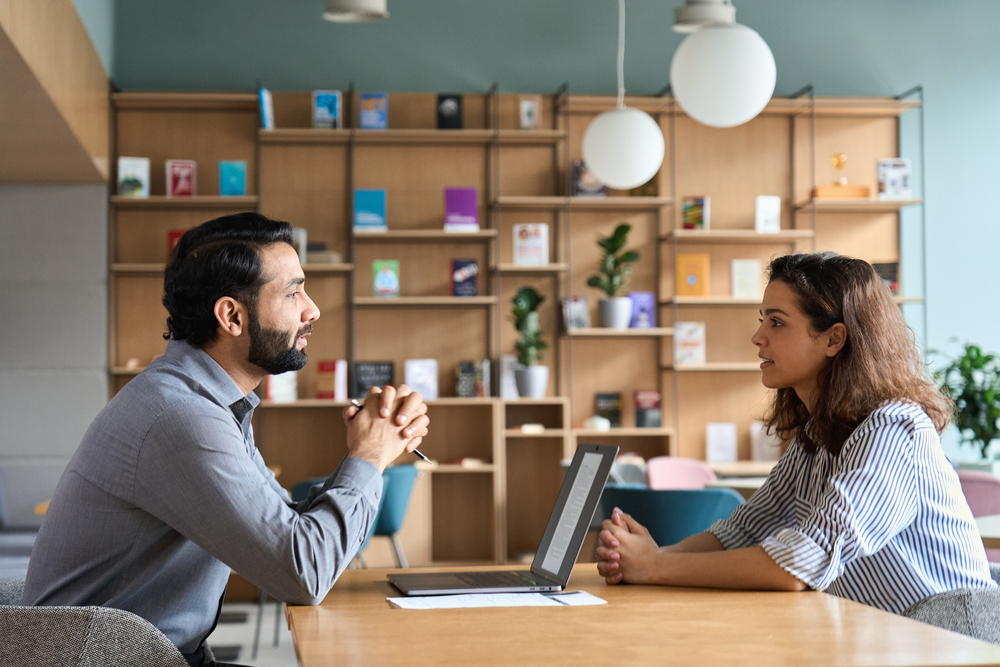 A man and a woman having a conversation with the man talking and the woman listening