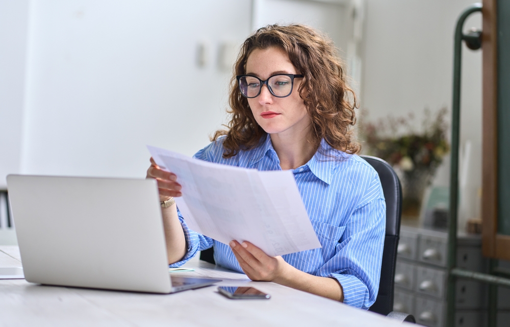 A young busy businesswoman wearing glasses and going through her documents