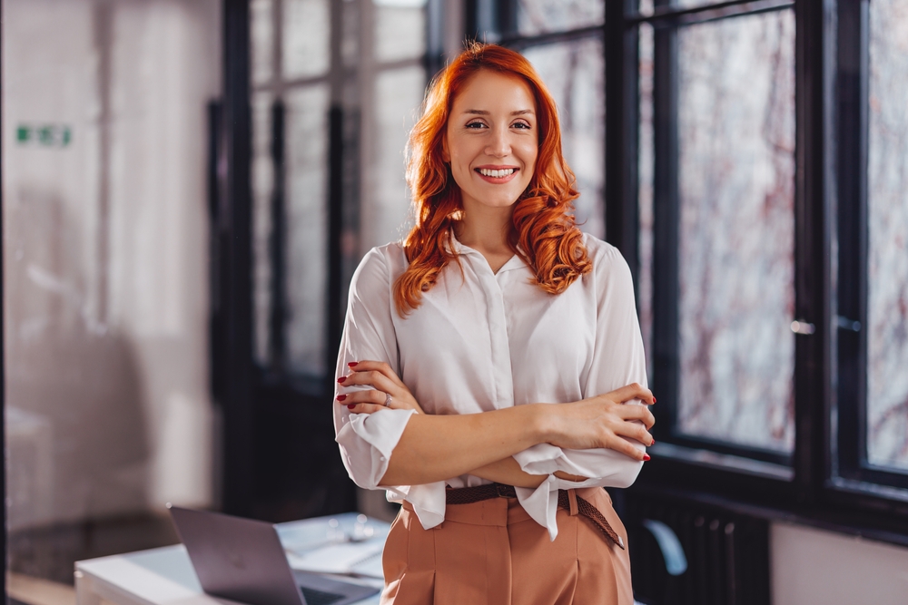 A confident businesswoman standing with arms folded